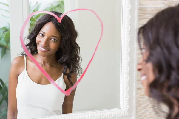 Ung kvinna som tittar i spegeln — Stockfoto