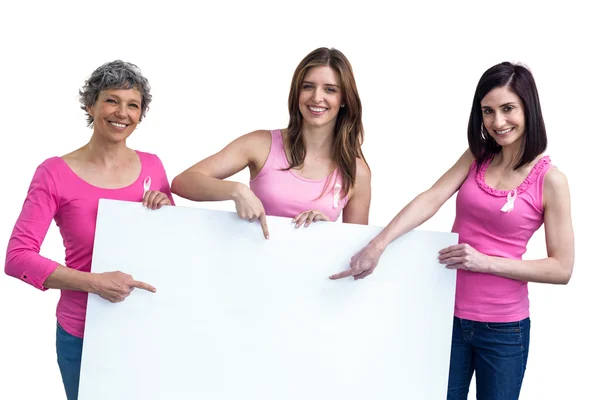 Women in pink outfits holding board — Stock Photo, Image