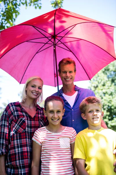 Familie staande onder paraplu — Stockfoto