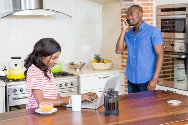 Femme utilisant un ordinateur portable dans la cuisine — Photo