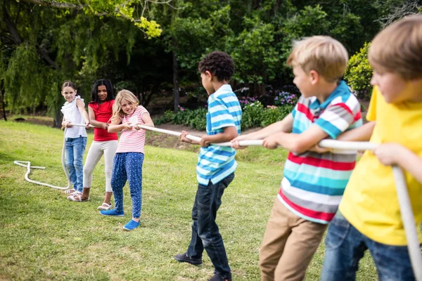 Kinder ziehen im Tauziehen ein Seil — Stockfoto