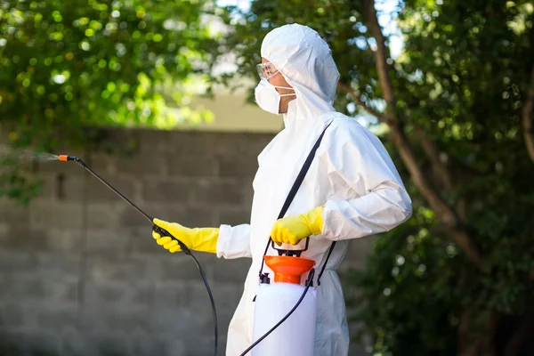 Worker using pesticide in back yard — Stock Photo, Image