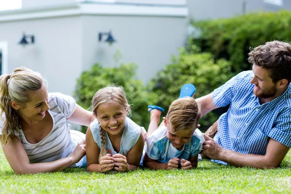 Ouders kietelen kinderen in tuin — Stockfoto