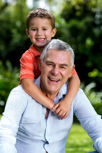 Grandfather with grandson sitting in yard — Stock Photo, Image