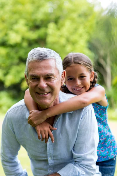 Grandfather with grandaughter at yard — Stock Photo, Image