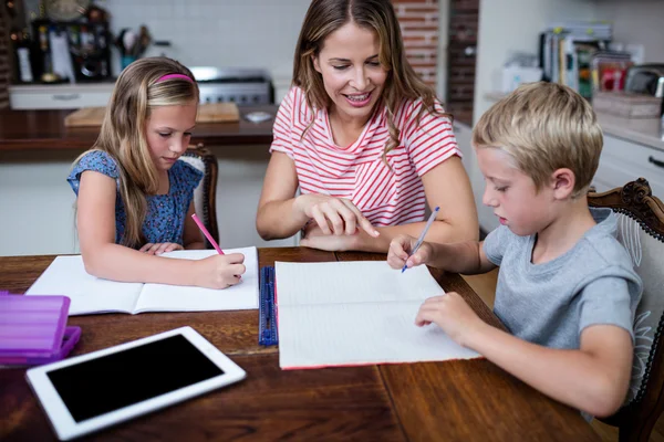 Çocuklar ev ödevlerinde yardımcı anne — Stok fotoğraf