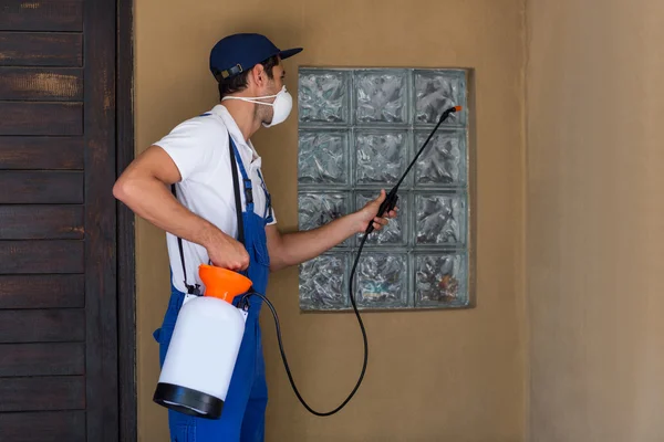 Operaio che spruzza prodotto chimico sulla finestra — Foto Stock