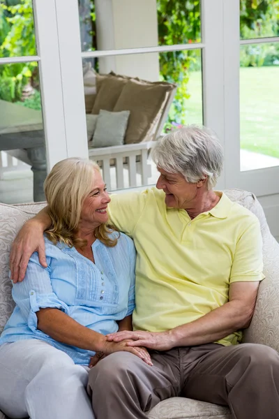 Glückliches Seniorenpaar auf Sofa sitzend — Stockfoto