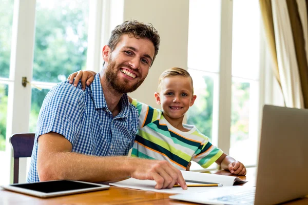 Pai e filho sentados à mesa — Fotografia de Stock