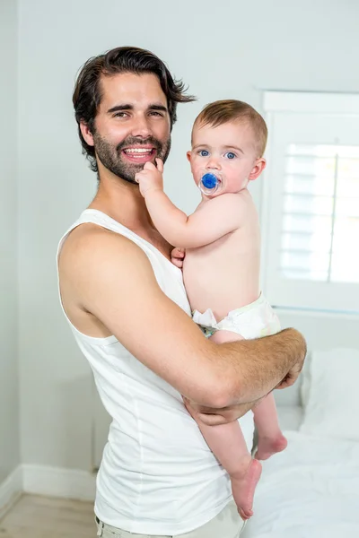 Padre llevando bebé hijo por la cama — Foto de Stock