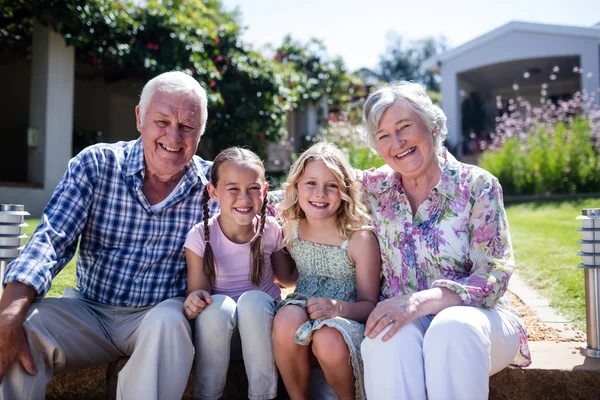 Großeltern und Enkelinnen sitzen im Garten — Stockfoto