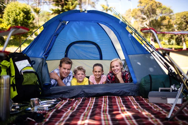 Счастливая семья лежит в палатке — стоковое фото