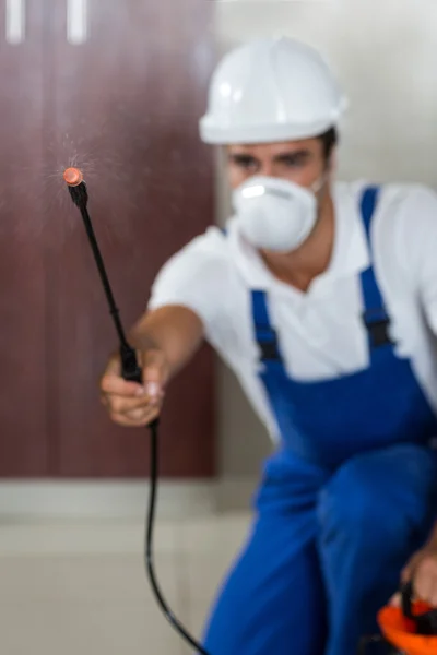 Handarbeiter versprüht Insektizid in Küche — Stockfoto
