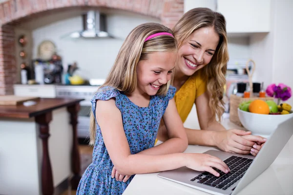 Mor och dotter med laptop i köket — Stockfoto