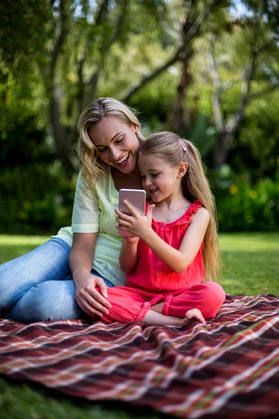 Daughter showing phone to mother in yard — Stock Photo, Image