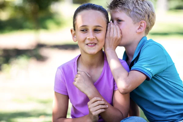 Brother whispering in sisters ear — Stock Photo, Image