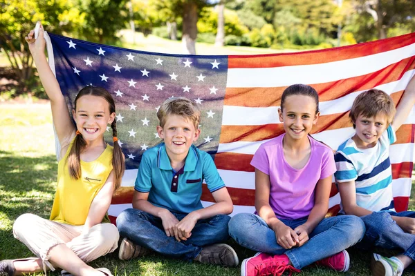 Crianças segurando bandeira americana no parque — Fotografia de Stock