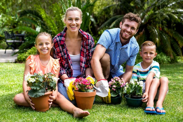 Семья с цветочными горшками на траве — стоковое фото