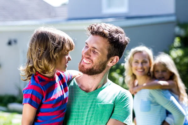 Parent portant des enfants dans la cour — Photo