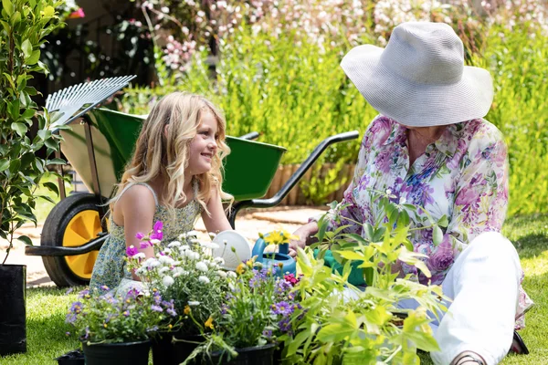 Grandmother and granddaughter watering plants — Stock Photo, Image