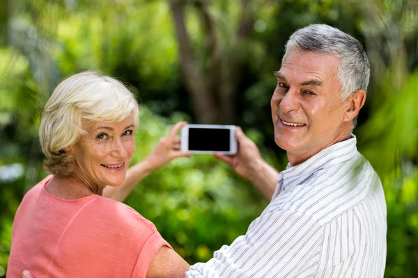 Pareja tomando selfie mientras de pie en el patio —  Fotos de Stock