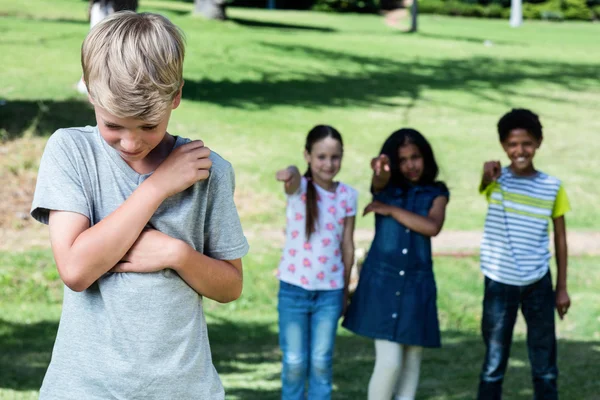 Vrienden plagen een jongen — Stockfoto