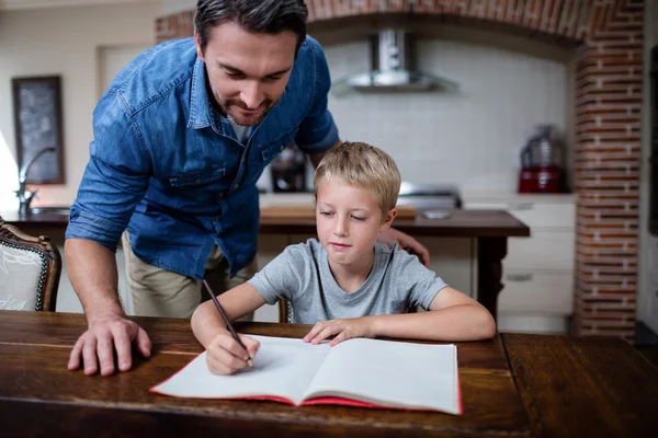 Otec pomáhá synovi s domácím úkolem — Stock fotografie