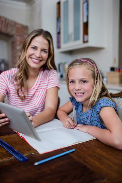 Mor använder tablet samtidigt hjälpa dotter — Stockfoto