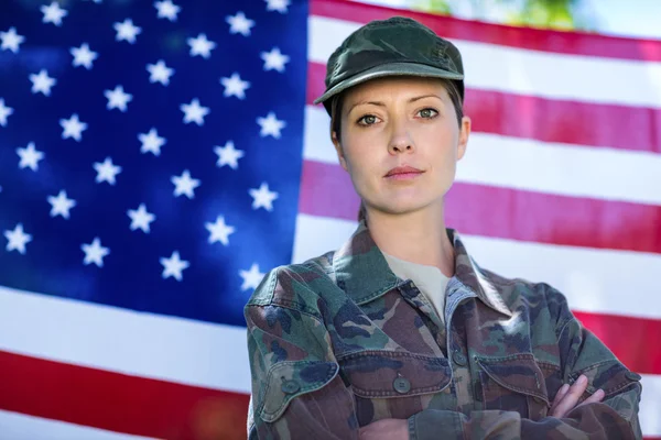 Katona amerikai zászló előtt áll — Stock Fotó
