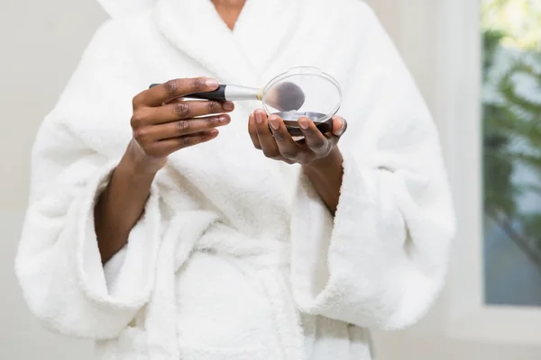 Mulher segurando fundação e escova — Fotografia de Stock