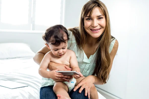 Mãe com filho segurando celular — Fotografia de Stock