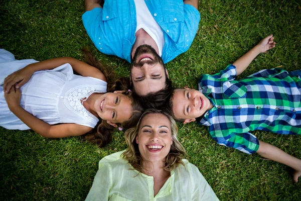 Family lying on grass in yard — Stock Photo, Image