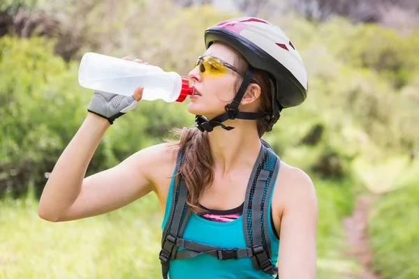 Woman drinking water and wearing helmet — Stock Photo, Image