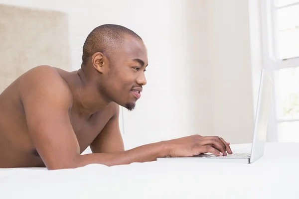 Hombre joven usando el ordenador portátil — Foto de Stock