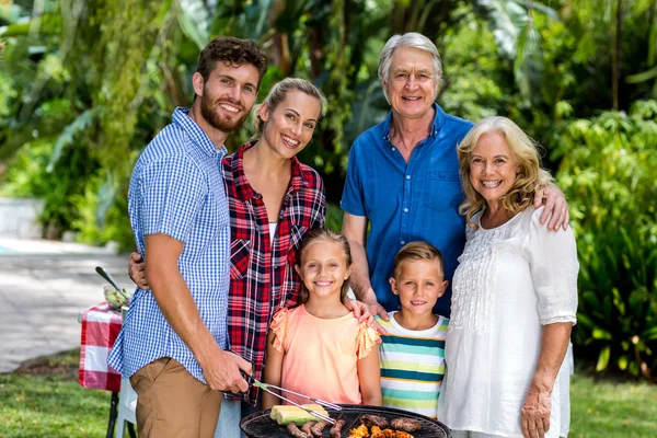 Family grilling food in barbeque at yard — Stock Photo, Image