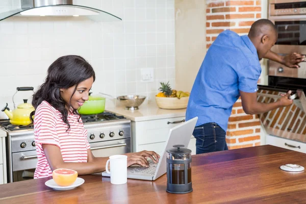 Donna che utilizza il computer portatile in cucina — Foto Stock