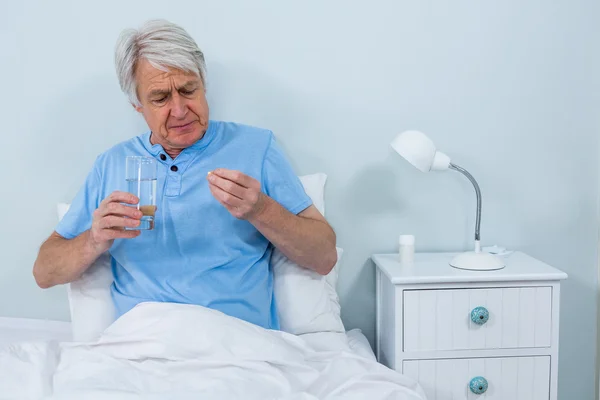 Starší muž bere pilulky — Stock fotografie