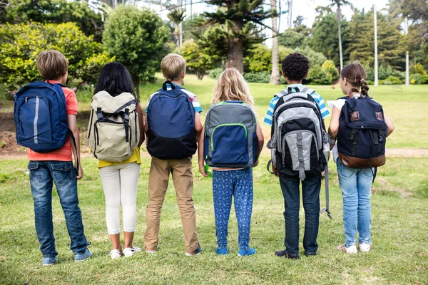 Çocukların birlikte ayakta çanta ile arkadan görünüş — Stok fotoğraf