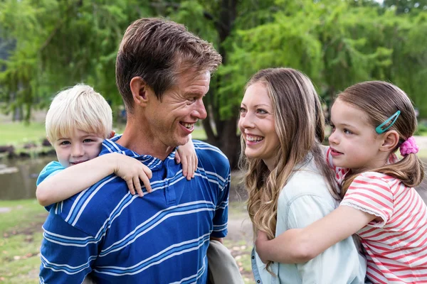 Parents giving piggy back to kids — Stock Photo, Image