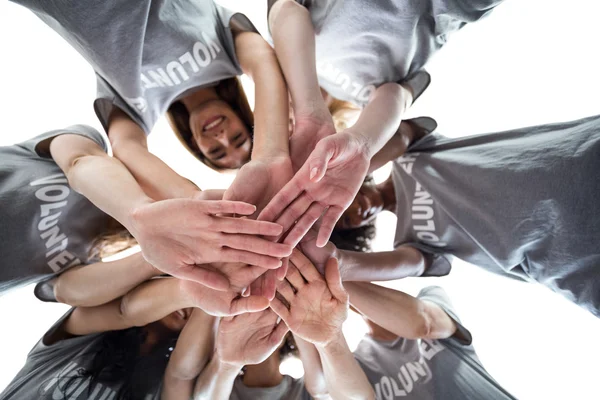 Voluntarios en círculo poniendo las manos juntas — Foto de Stock