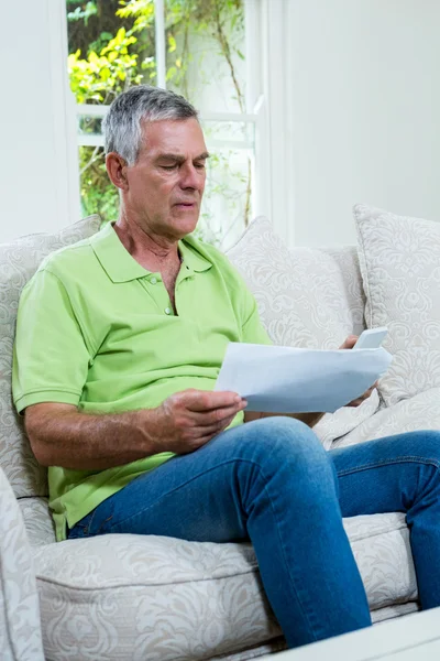 Worried senior man holding documents — Stock Photo, Image