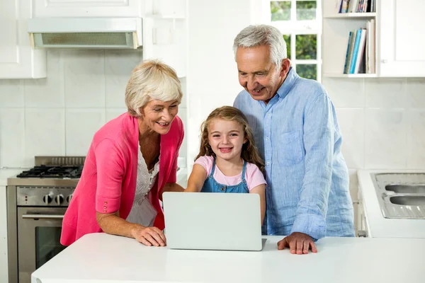 Abuelos y niña usando ordenador portátil —  Fotos de Stock