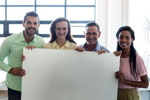 Colegas segurando placa em branco — Fotografia de Stock