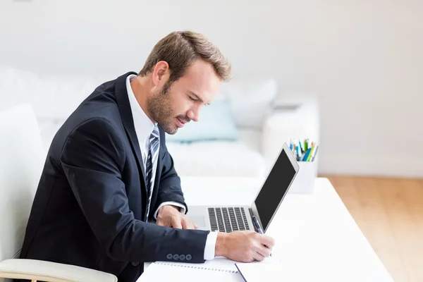 Affärsman med laptop på skrivbordet — Stockfoto