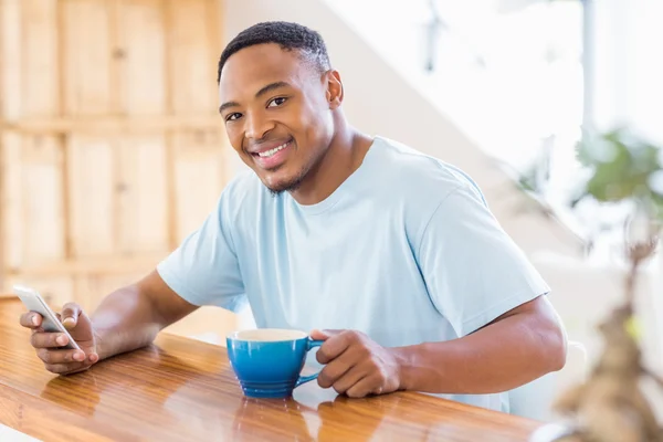 Homem usando telefone enquanto toma café — Fotografia de Stock