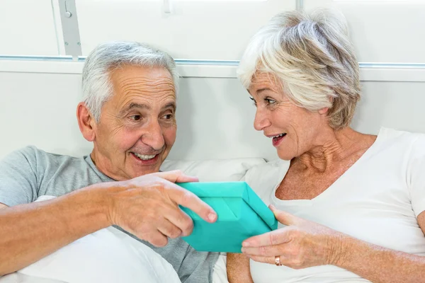 Uomo che dona alla donna sul letto — Foto Stock