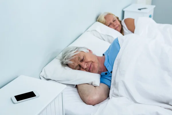 Äldre par vilandes på sängen — Stockfoto