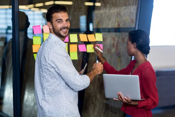 Collega's schrijven op plaknotities — Stockfoto