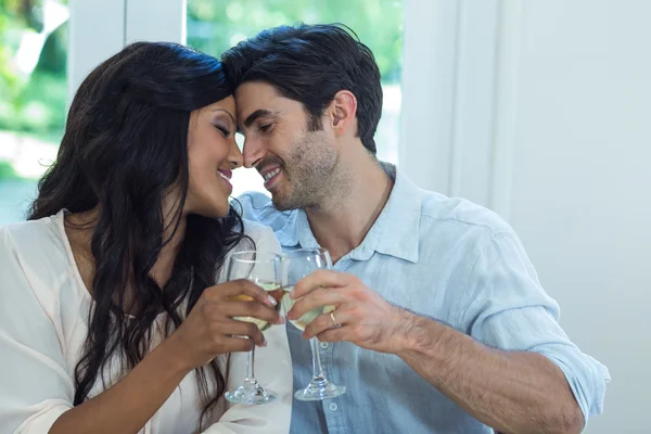 Paar reibt sich Nase und prostet Wein zu — Stockfoto