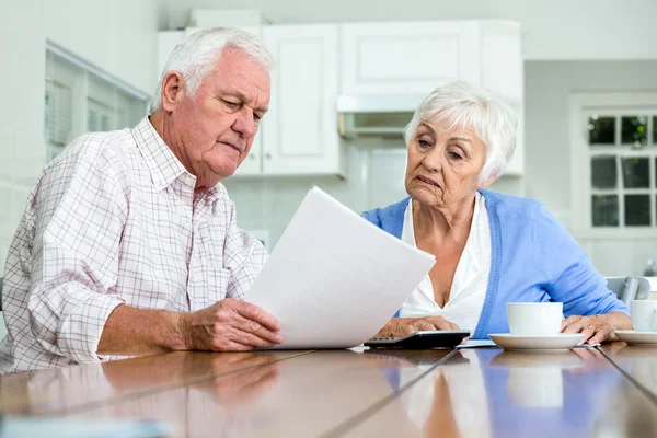 Couple with documents sitting at table — Stock Photo, Image